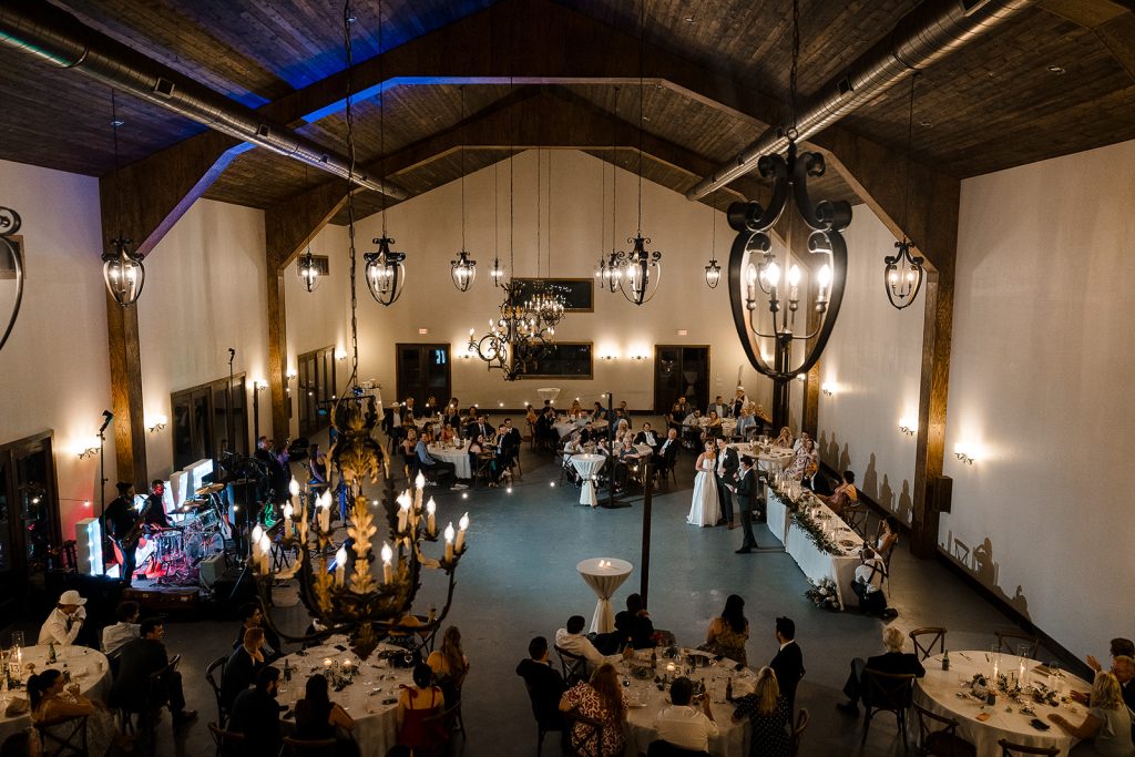 Austin wedding venue reception with luxury decor, wedding tables, chandeliers, cocktail tables and wedding guests enjoying the celebration