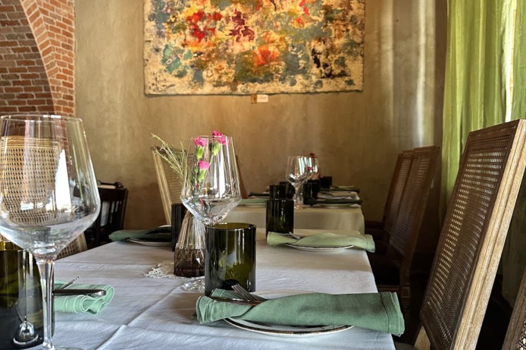 Elegant dining table setup inside a Mediterranean restaurant Miami, featuring glassware, linens, and warm interior decor.