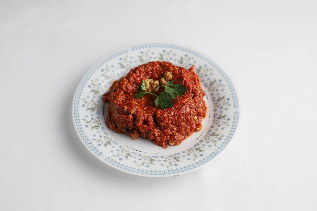 Spicy Mediterranean tomato dip served on a patterned plate at a Mediterranean restaurant Miami.