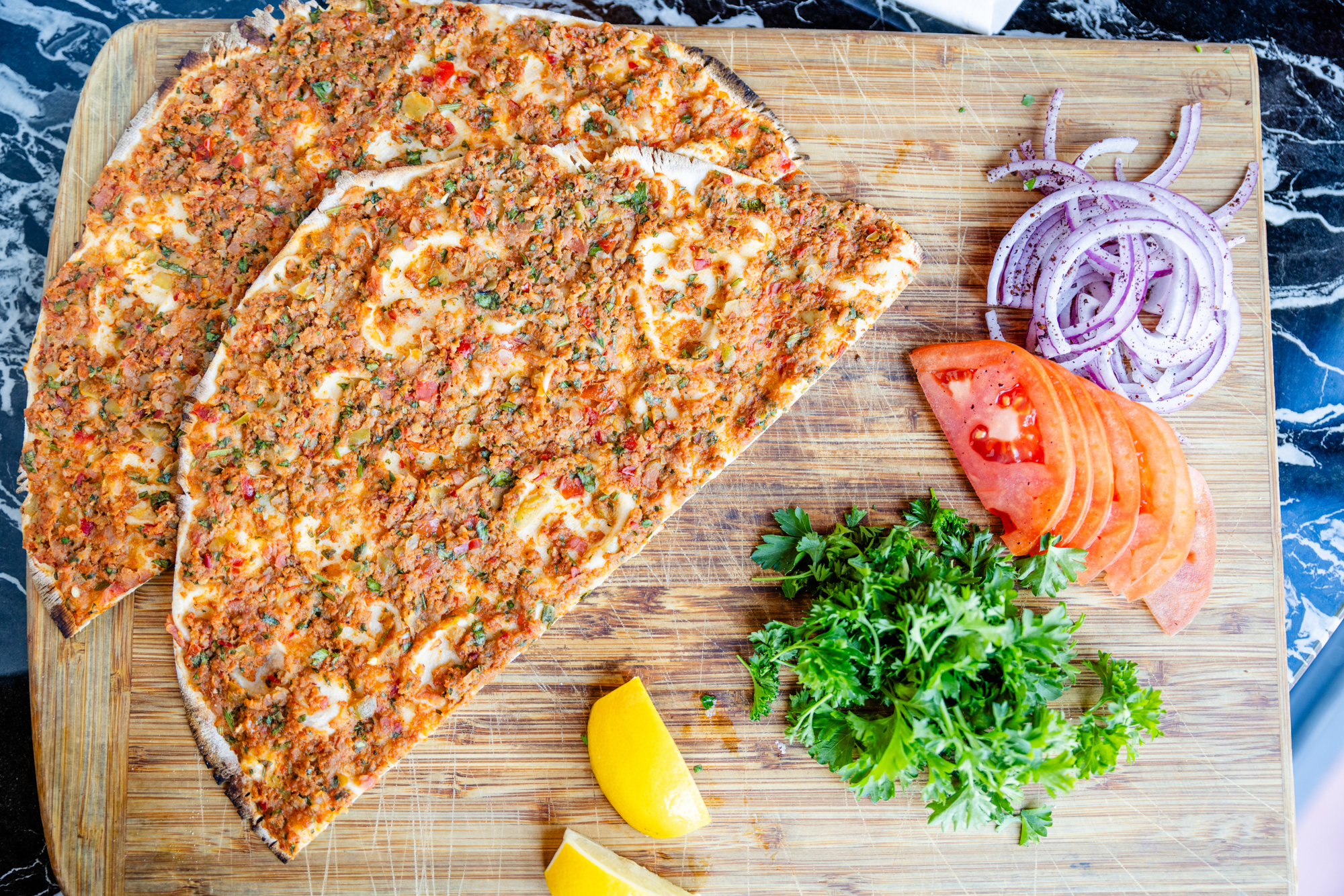 Freshly baked lahmacun at Babylon South Beach – best lahmacun in Miami served hot with lemon and parsley.
