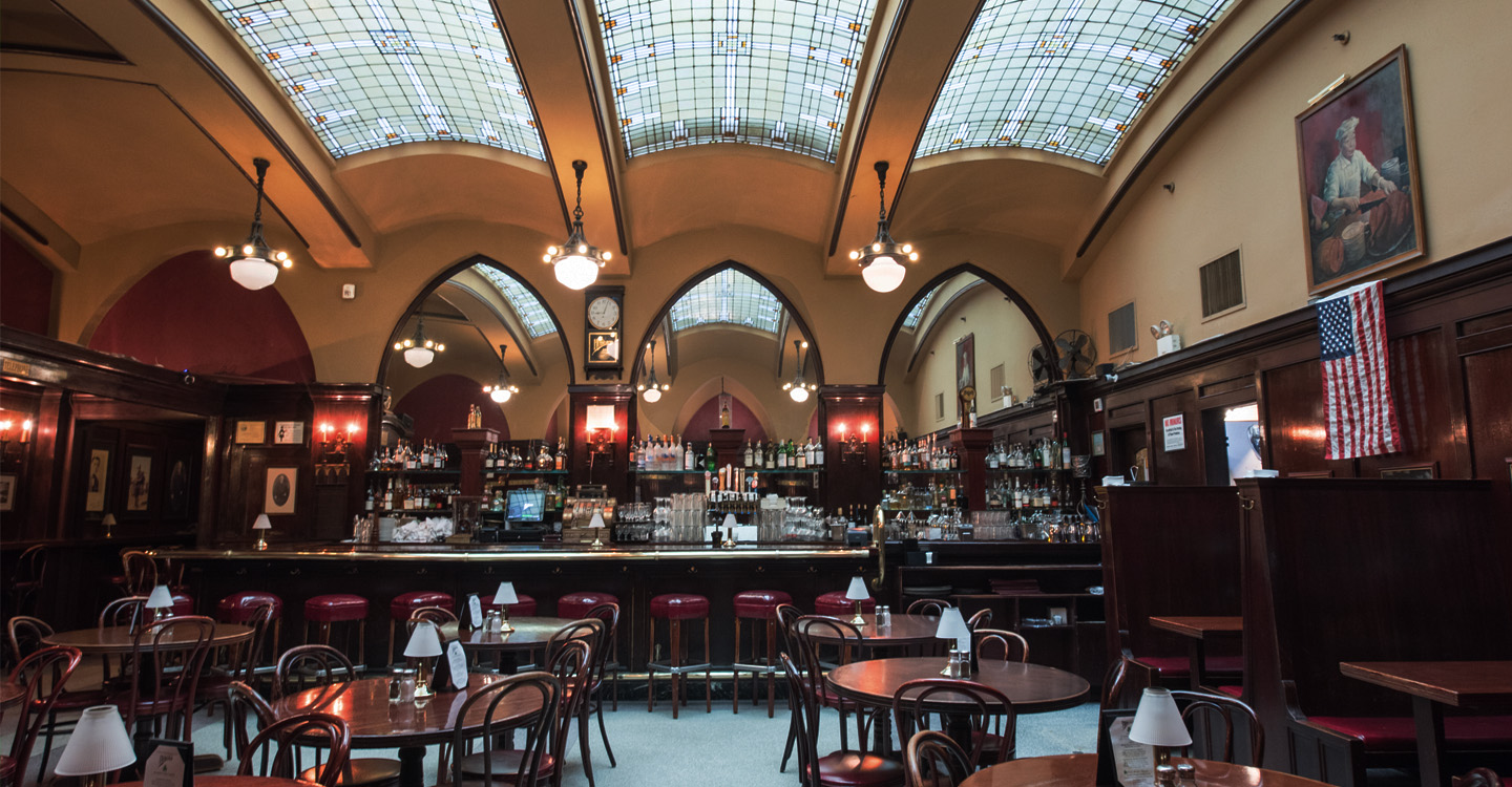 Historic bar and restaurant with arched mirrors and terrazzo tile.