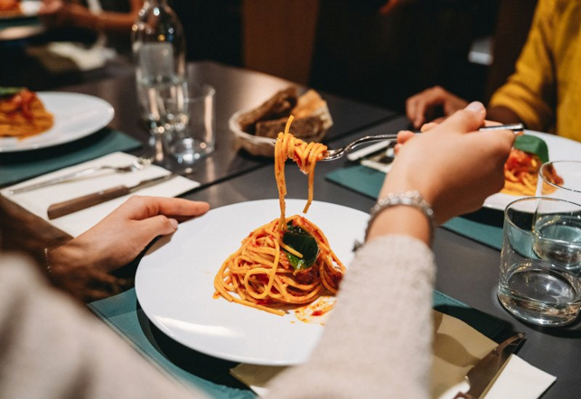 A female is eating food at Colletti's Dining and Banquets in Chicago's Jefferson Park neighborhood