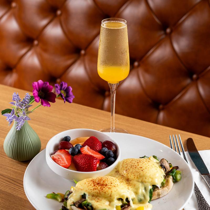 Eggs Benedict with fresh fruit and a mimosa served at 5800 North Cafe