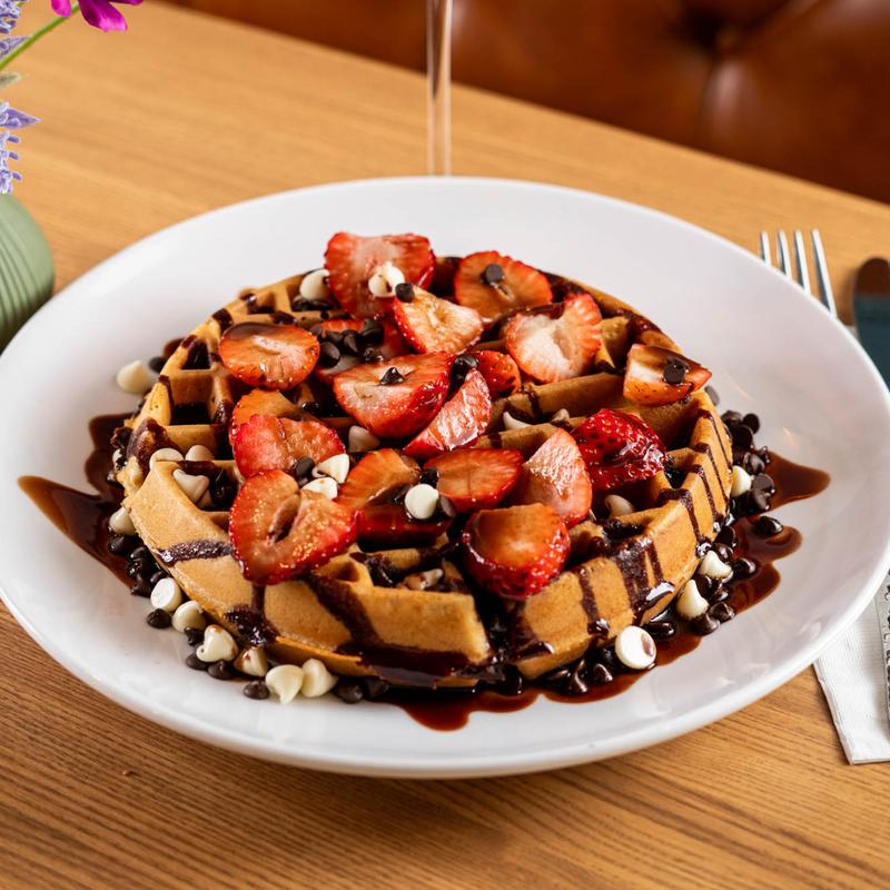 Strawberry chocolate waffle topped with fresh strawberries and chocolate drizzle at 5800 North Cafe