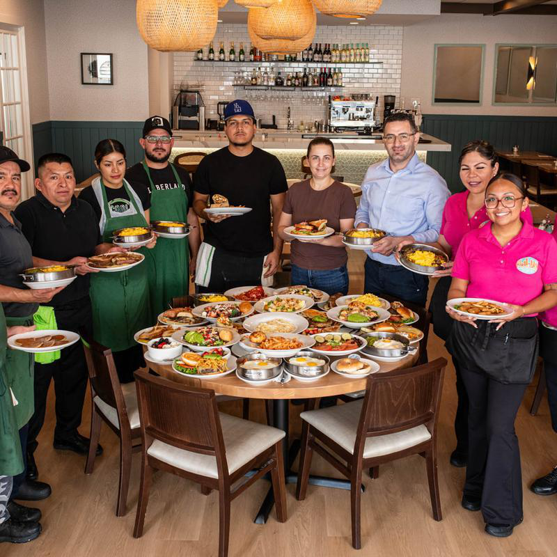 5800 North Cafe team standing around a table filled with breakfast dishes inside the Chicago restaurant