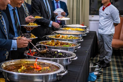 People serving themselves food at a corporate catering event.