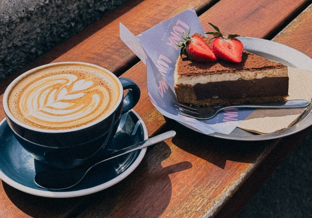 A cup of coffee with a pastry beside it