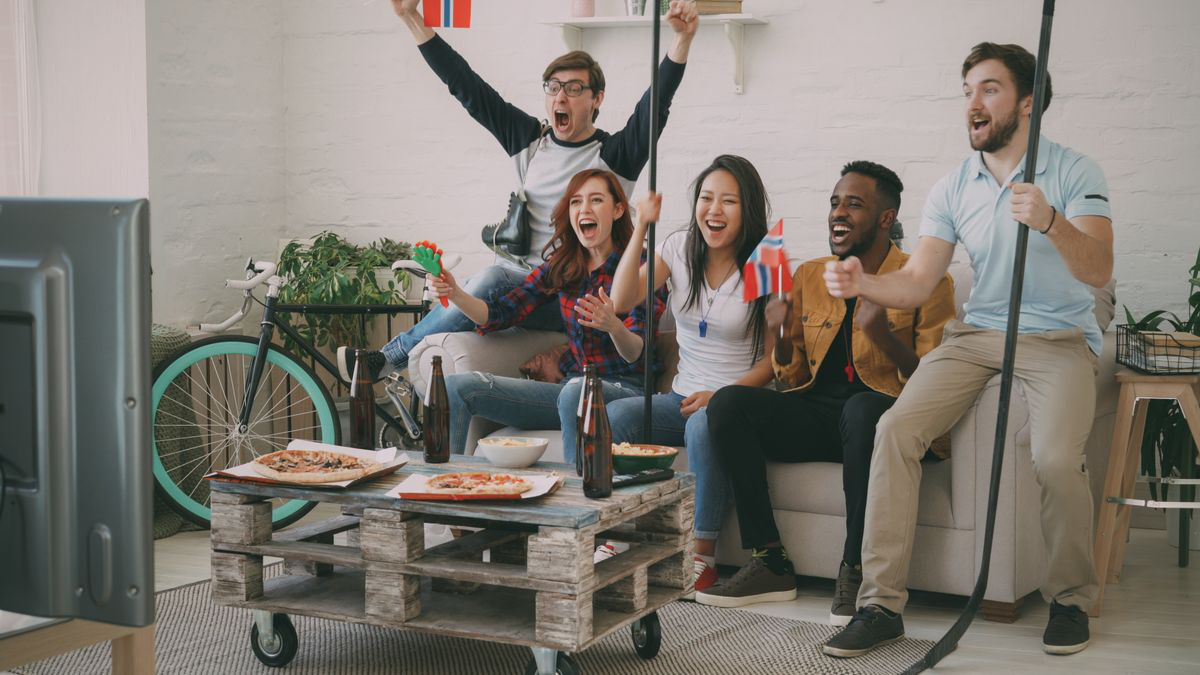 Friends cheering while watching sports together