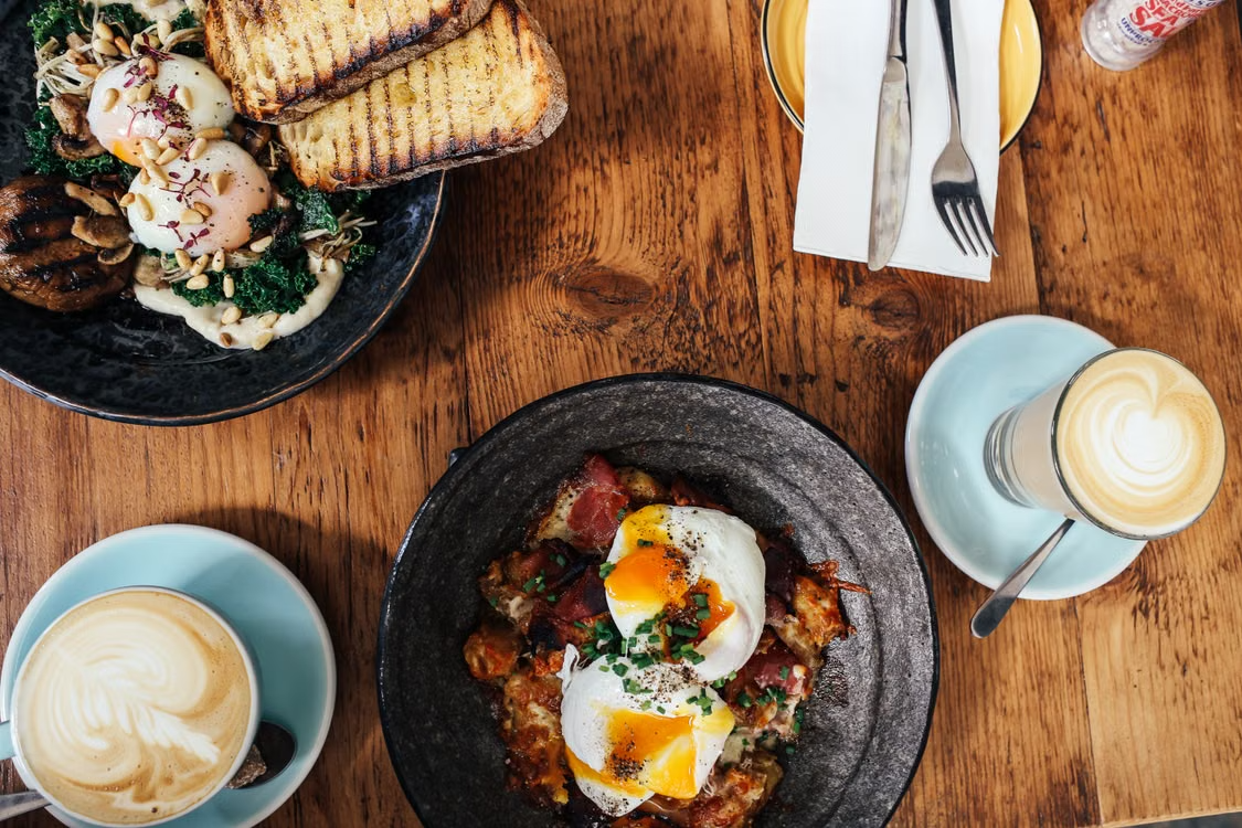 top-view of two meals and two lattes on the table