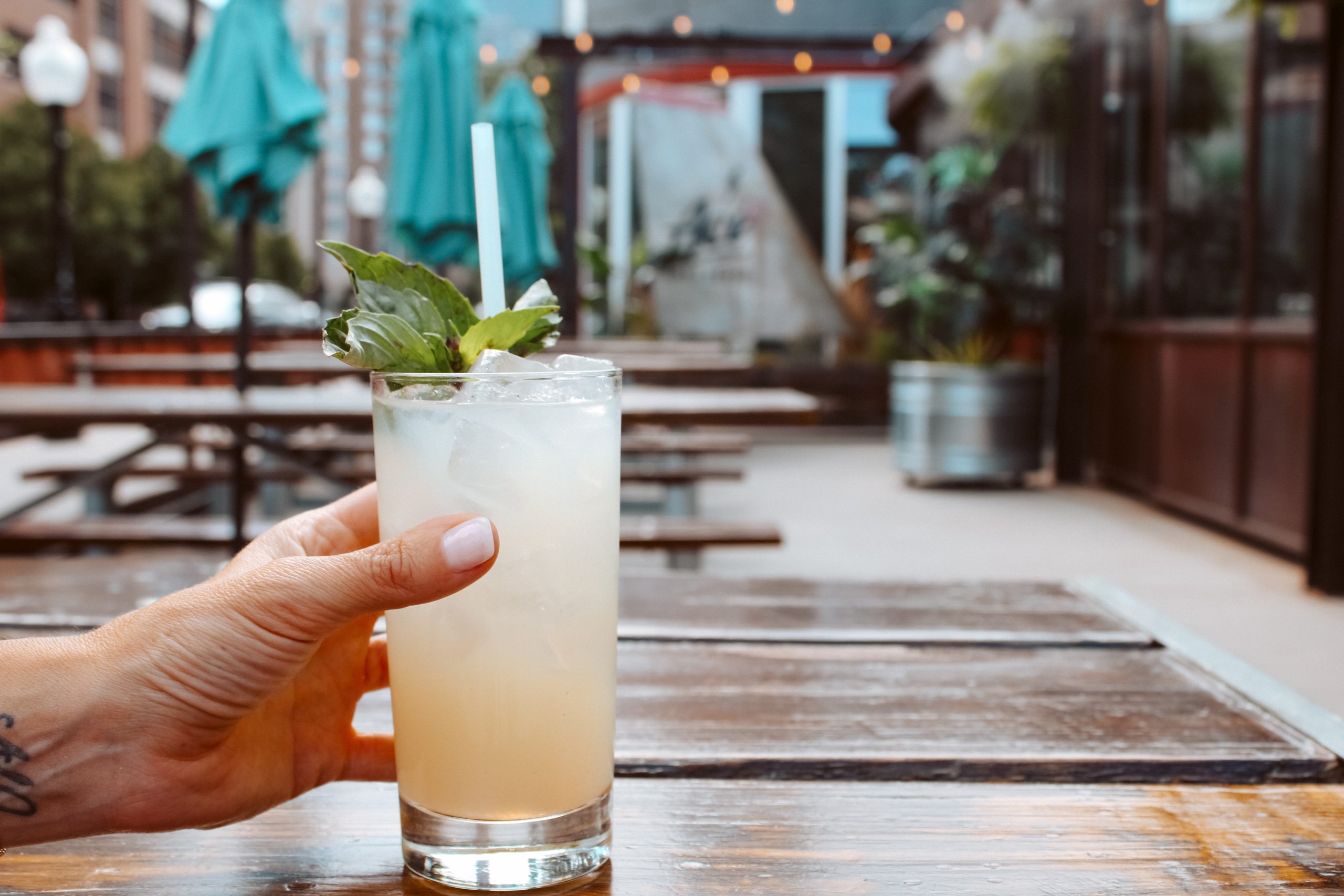 Hand holding a drink in an outdoor event space