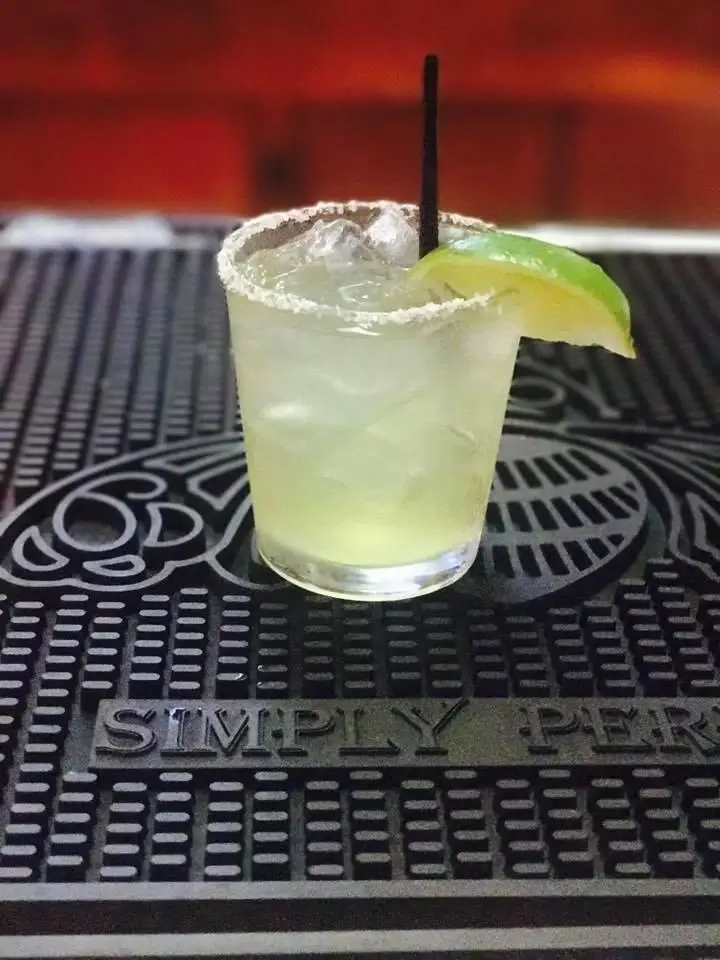 Margarita with lime on bar mat.