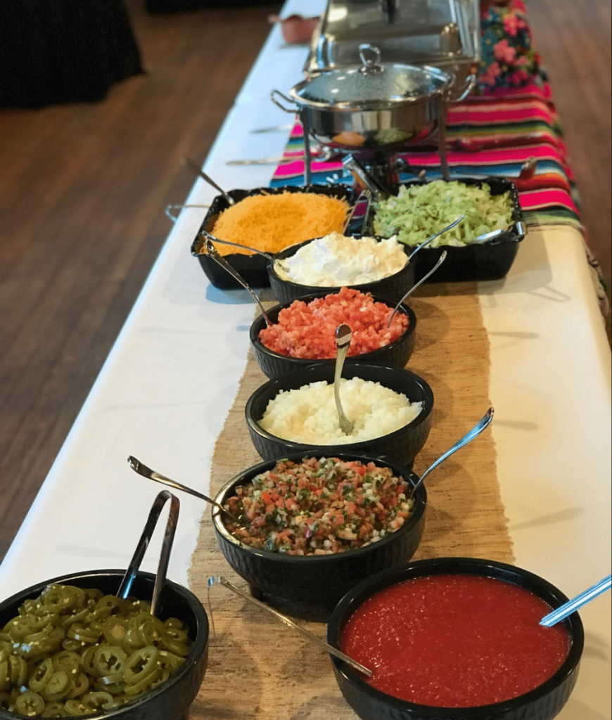 Toppings table with jalapeños, pico de gallo, and salsa.