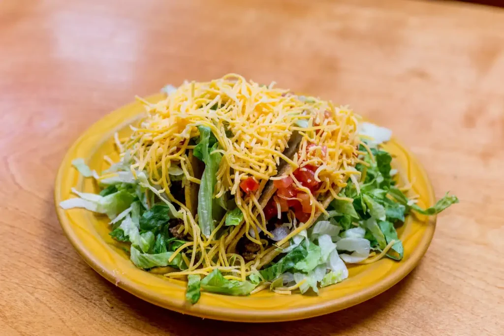 Crispy tacos stuffed with seasoned meat, lettuce, tomatoes, and shredded cheddar cheese.