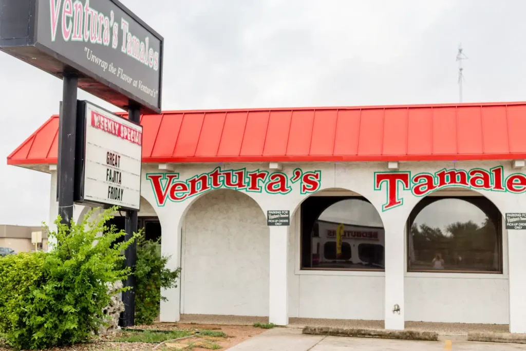 Exterior view of Ventura’s Tamales restaurant with a red roof and white stucco walls.
